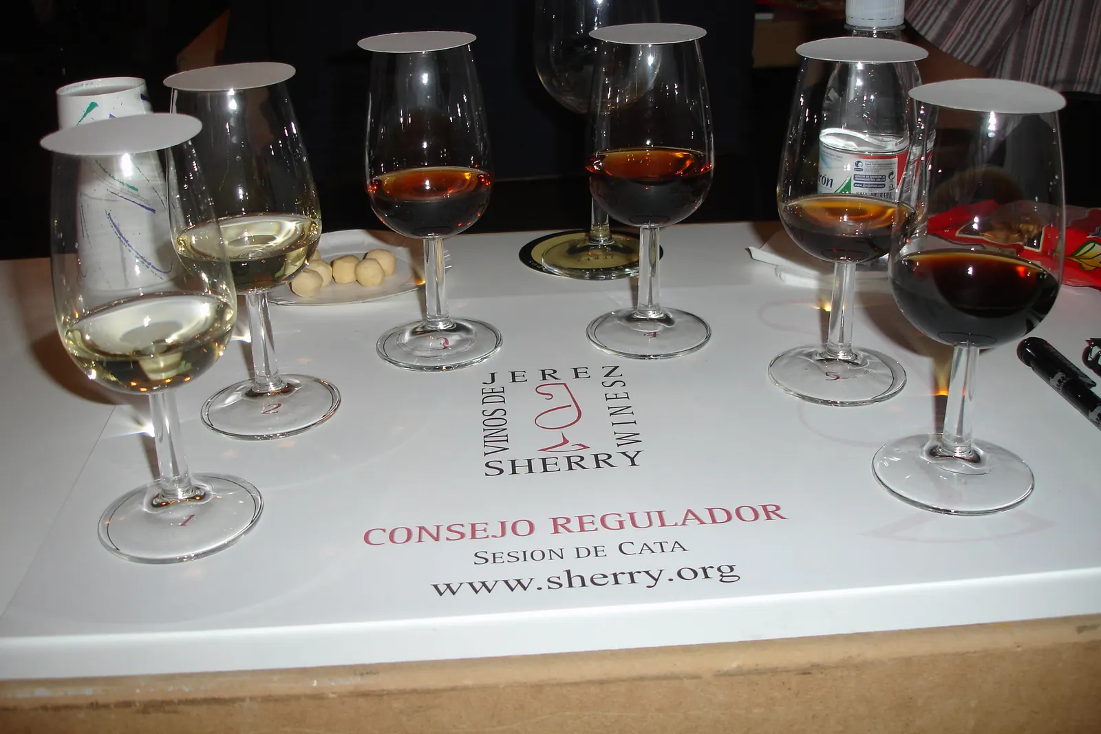 Bicchieri di degustazione di sherry, dal più chiaro al più scuro, su un vassoio bianco da degustazione a Jerez de la Frontera